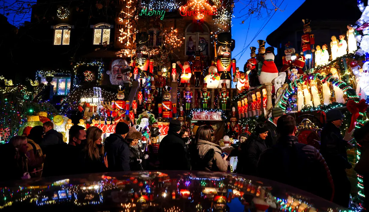 Wisatawan melihat sebuah rumah yang dihiasi lampu Natal di lingkungan Dyker Heights, Brooklyn, New York, Amerika Serikat, 21 Desember 2022. Kawasan di Brooklyn itu telah menyatukan orang selama 30 tahun dengan pameran lampu yang spektakuler. (AP Photo/Julia Nikhinson)