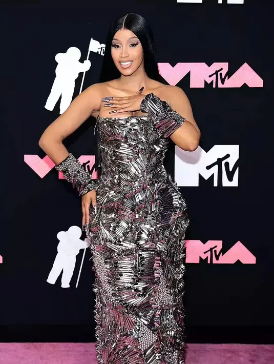 Cardi B nggak kalah nyentrik saat muncul di karpet merah mengenakan gaun strapless yang terbuat dari Hair Clip.