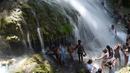 Sejumlah peziarah mandi di bawah air terjun di Saut d' Eau, Haiti (15/7). Ini merupakan ritual tahunan untuk menyembuhkan penyakit dan mensucikan diri. (AFP Photo/Hektor Retamal)