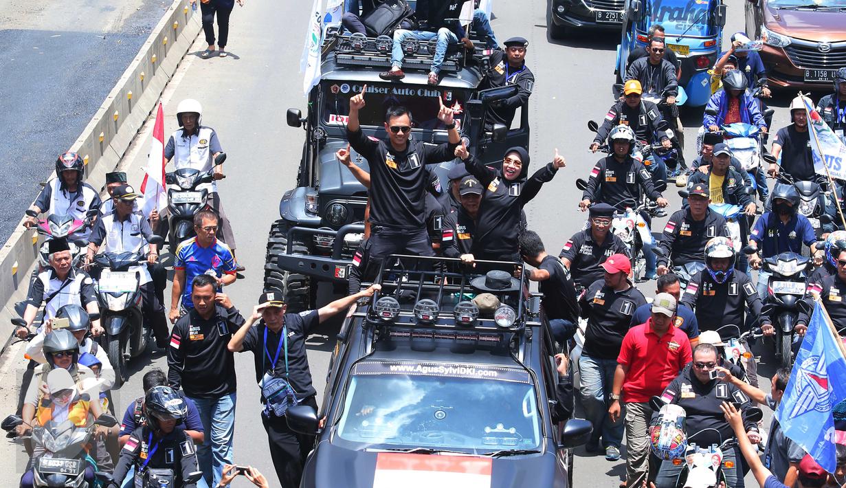 Pasangan Agus H Yudhoyono dan Sylviana Murni menyapa warga saat berada di mobil karnaval di Thamrin, Jakarta, Sabtu (29/10). Karnaval tersebut merupakan bentuk kampanye damai untuk pemilihan Gubernur DKI Jakarta. (Liputan6.com/Angga Yuniar)