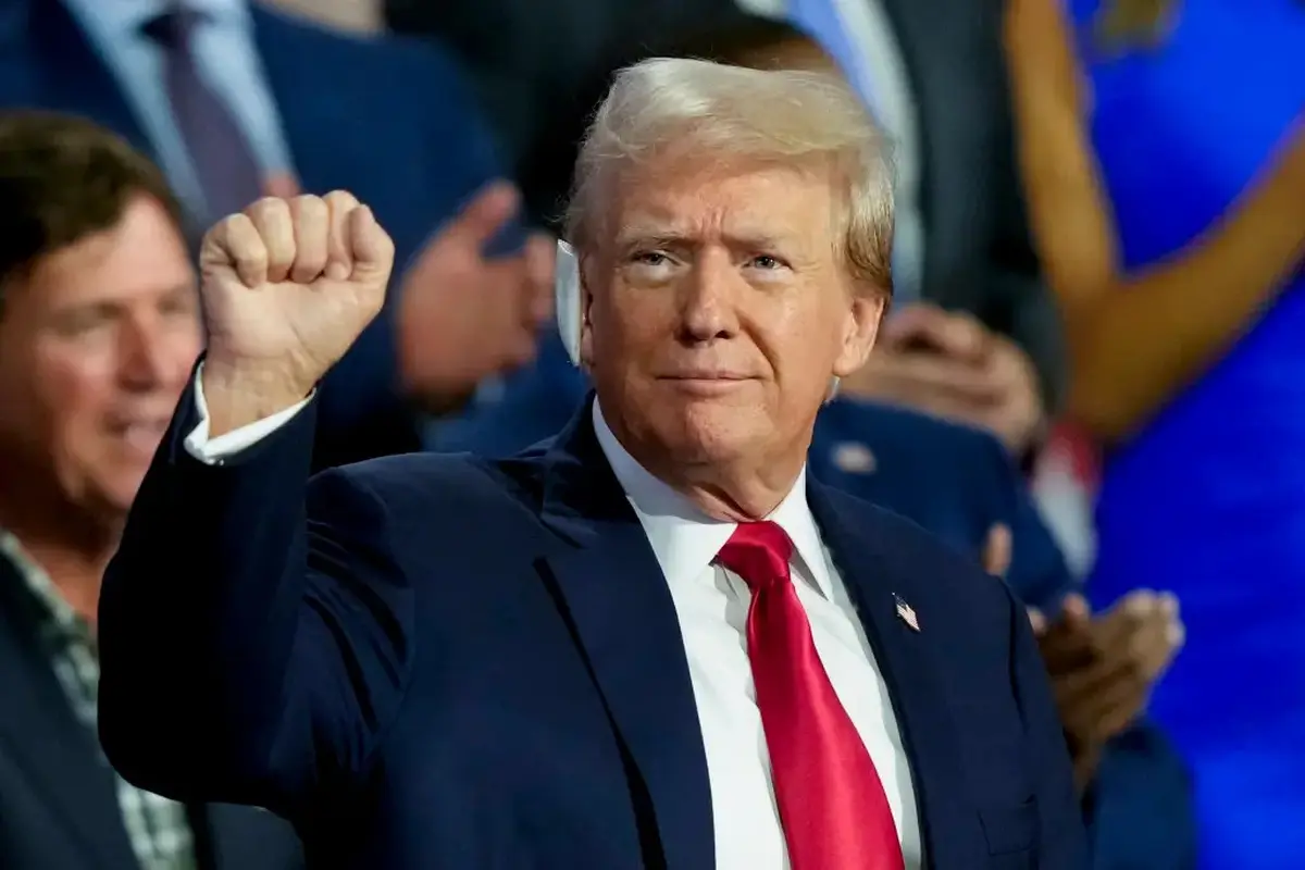 Donald Trump dengan perban di telinga, mengangkat tinjunya ke udara ketika massa bersorak atas kedatangannya di RNC atau Konvensi Partai Demokrat. (AP).