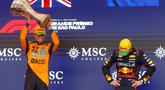 Pembalap Red Bull Racing, Max Verstappen (kanan) tertunduk saat pembalap McLaren, Lando Norrris mengangkat trofi kemenangan dalam Formula 1 GP Sao Paulo di Interlagos, Sao Paulo, Brasil, Minggu (09/11/2025). (AFP/Miguel Schincariol)