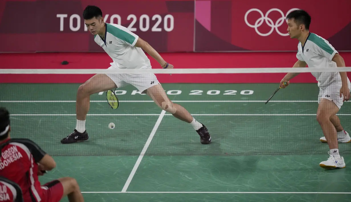 Pebulu tangkis Taiwan Lee Yang / Wang Chi-Lin saat bertanding melawan pebulu tangkis Indonesia Kevin Sanjaya / Marcus Gideon pada babak penyisihan grup ganda putra Olimpiade Tokyo 2020 di Tokyo, Jepang, Selasa (27/7/2021). Kevin Sanjaya / Marcus Gideon kalah. (AP Photo/Dita Alangkara)