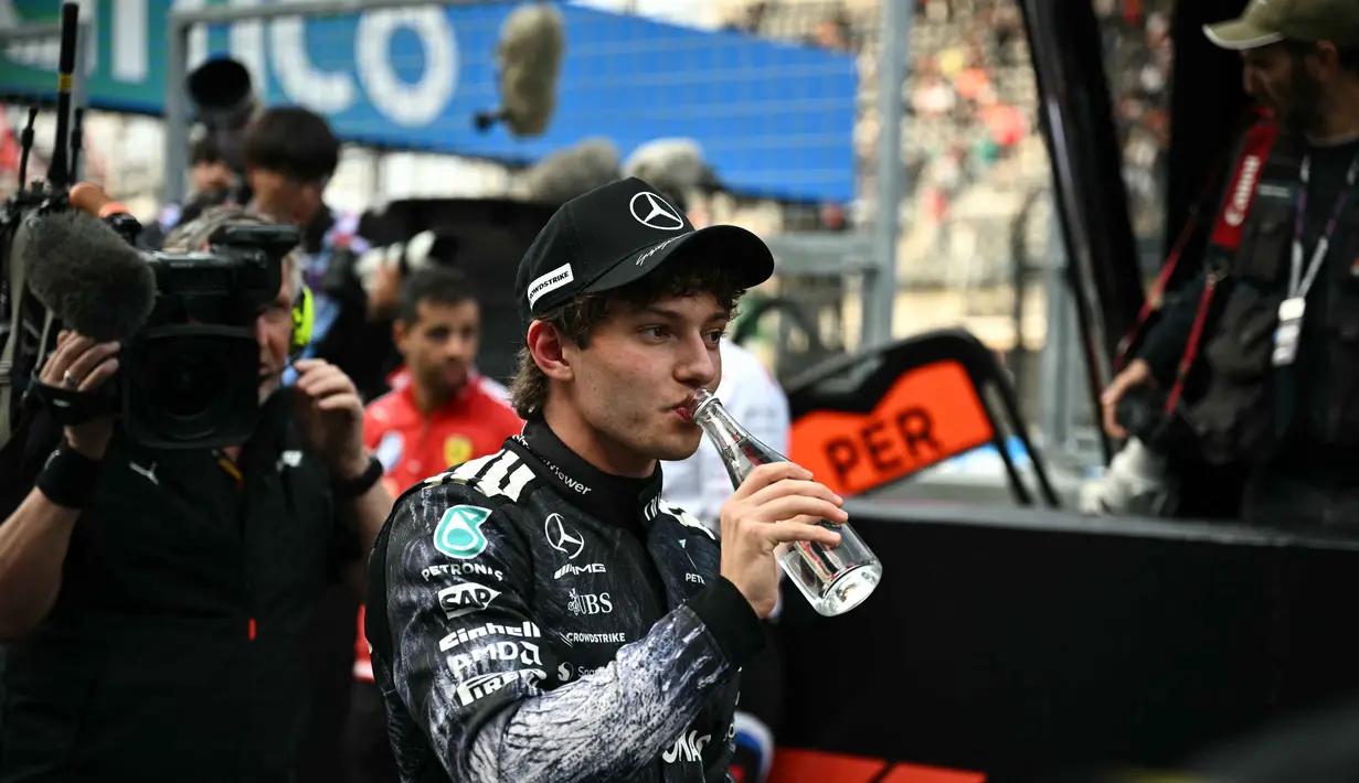 Ia mencatat waktu tercepat 1:28.778 dalam sesi kualifikasi yang digelar di Sirkuit Suzuka, pada Sabtu (28/3/2026). Tampak dalam foto, pembalap Mercedes AMG Petronas asal Italia, Kimi Antonelli, minum air setelah meraih pole position pada sesi kualifikasi Formula 1 GP Jepang 2026 di Sirkuit Suzuka, pada Sabtu (28/3/2026). (Philip FONG/AFP)