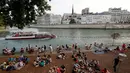 Orang-orang duduk  saat berkumpul di tepi sungai Seine sebagai bagian dari acara musim panas Paris Plages di Paris, Prancis (7/7). (AFP Photo/Francois Guillot)