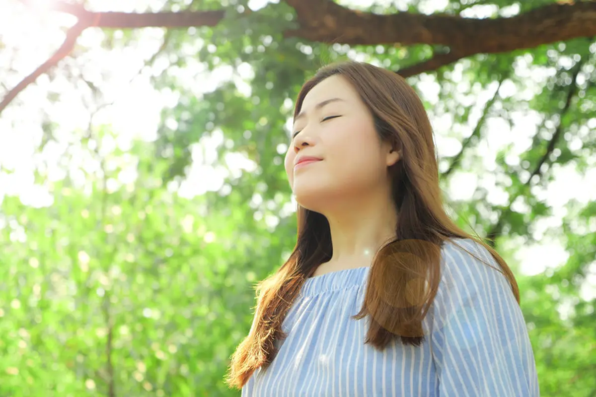 perempuan menghirup udara pagi