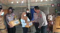 Polisi dan wartawan berikan bantuan untuk anak nakes yang meninggal karena Covid-19. (Foto: Liputan6.com/Felek Wahyu)