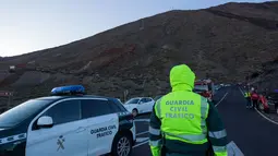Aparat keamanan berjaga di lereng Gunung El Teide (3.718 meter) di Taman Nasional El Teide, Pulau Canary, Spanyol, Rabu (15/3). Sekitar 60 wisatawan terperangkap di dua kereta gantung saat menuju puncak Gunung El Teide (3.718 meter). (Desiree Martin/AFP)