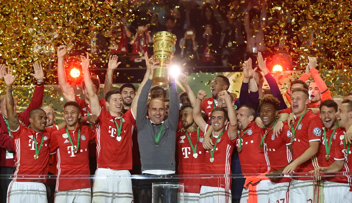 Pelatih Bayern Munchen, Pep Guardiola, mengangkat trofi juara DFB Pokal di Olympiastadion Berlin, Sabtu (25/5/2016). (AFP/Christof Stache) 