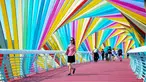 Warga berjalan melintasi jembatan warna-warni seperti pelangi yang berada di Qingdao, Shandong, China, Kamis (6/9). Jembatan pelangi ini terletak di Tangdaowan Seaside Park. (STR/AFP)