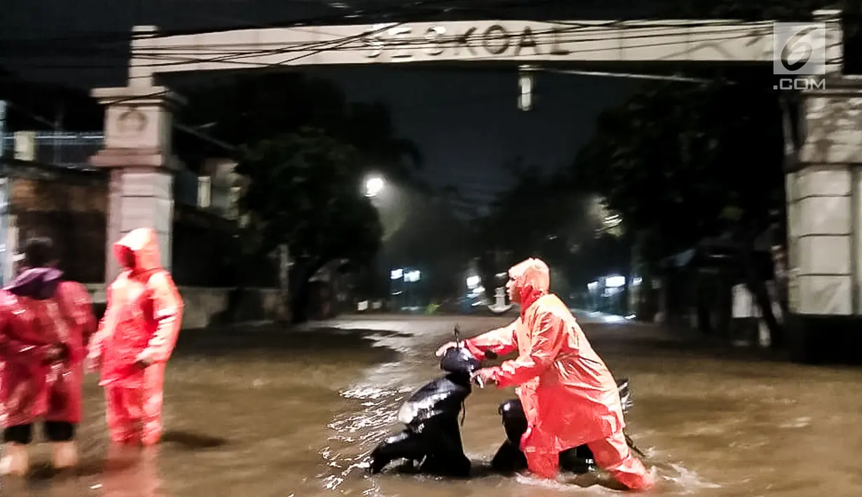 Pengendara mendorong motor saat banjir menggenangi kawasan Simpang Seskoal, Kebayoran Lama, Jakarta, Sabtu malam (16/2). Akibat banjir tersebut pengguna jalan diarahkan ke Jalan Panjang Cidodol atau putar balik ke Kebayoran Lama. (Liputan6.com/Septian)