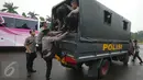 Petugas kepolisian menaiki truk pengangkut saat melakukan pengamanan di kawasan Monas, Jakarta, Selasa (18/4). Polda Metro Jaya dan Kodam Jaya mengerahkan 64.523 personel gabungan untuk mengawal Pilkada DKI 2017 putaran kedua. (Liputan6.com/Faizal Fanani)