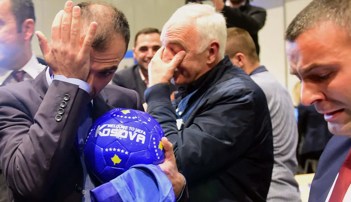 Delegasi sepak bola Kosovo menangis bahagia saat merayakan diterimnya Kosovo sebagai anggota UEFA pada kongres UEFA ke-40 tahun di Hungexpo Fair Center, Budapest, Hungaria, (3/52016). (AFP/Attila Kisbenedek)