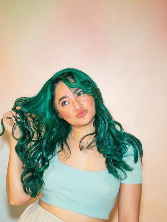 Dalam foto yang diunggah, Marshanda tampil mengenakan crop top mint yang serasi dengan warna rambut barunya. Ia berpose santai sambil menggulung rambut dan manyun ke arah kamera, memperlihatkan sisi ceria dan lucunya. Aura positif yang dipancarkan Marshanda membuat suasana foto terasa hidup dan menyenangkan. (Liputan6.com/IG/@marshanda99)