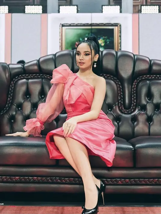 Jika ingin tampil lebih feminim, bisa mengenakan gaun seperti Lyodra dengan lengan organza di satu sisi. Dengan alas kaki heels agar semakin memerlihatkan kaki jenjangmu. (@lyodraofficial)