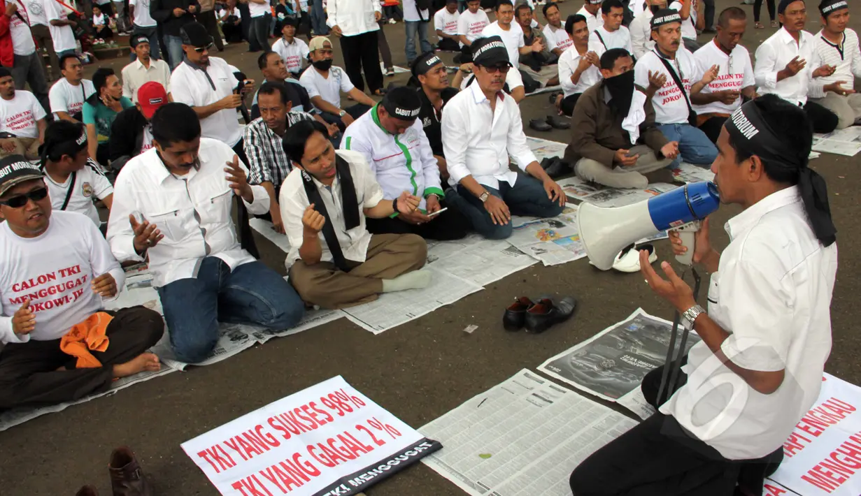 Massa dari Aliansi TKI Menggugat melakukan doa bersama saat aksi unjuk rasa di depan Istana Negara, Jakarta, Selasa (7/4/2015).  Mereka menuntut Presiden Jokowi mencabut moratorium larangan pengiriman TKI ke Timur Tengah. (Liputan6.com/Helmi Afandi))
