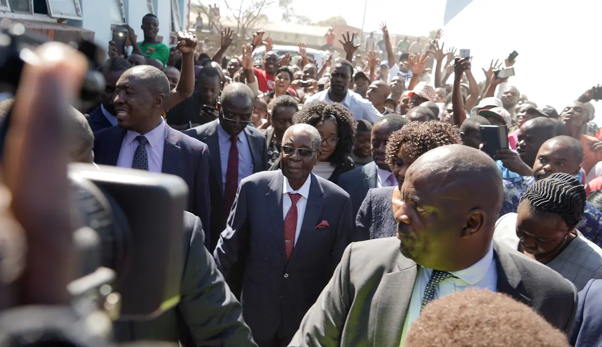 Mantan Presiden Zimbabwe, Robert Mugabe tiba untuk memberikan suara dalam pemilihan umum negara itu di TPS distrik Highfield, Harare, Senin (30/7). Mugabe pertama kalinya menggunakan hak pilihnya setelah dilengserkan November 2017. (AFP/Zinyange AUNTONY)