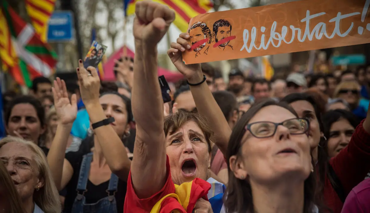 Sejumlah orang bereaksi ketika Parlemen Catalonia mendeklarasikan kemerdekaan dari Spanyol di luar gedung parlemen di Barcelona, Jumat (27/10). Sejumlah pendukung kemerdekaan, turun ke jalan dan meneriakkan 'Liberty'. (AP/Santi Palacios)