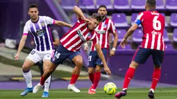 Pemain Atletico Madrid, Marcos Llorente, berebut bola dengan pemain Real Valladolid, Oscar Plano, pada laga Liga Spanyol di Stadion Jose Zorrilla, Sabtu (22/5/2021). Atletico Madrid menang dengan skor 2-1. (AP/Manu Fernandez)