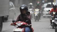 Pengendara motor menggunakan masker untuk menghindari debu saat melintasi Jalan Kemukus, Tamansari, Jakarta, Senin (24/11/2014). (Liputan6.com/Faizal Fanani)