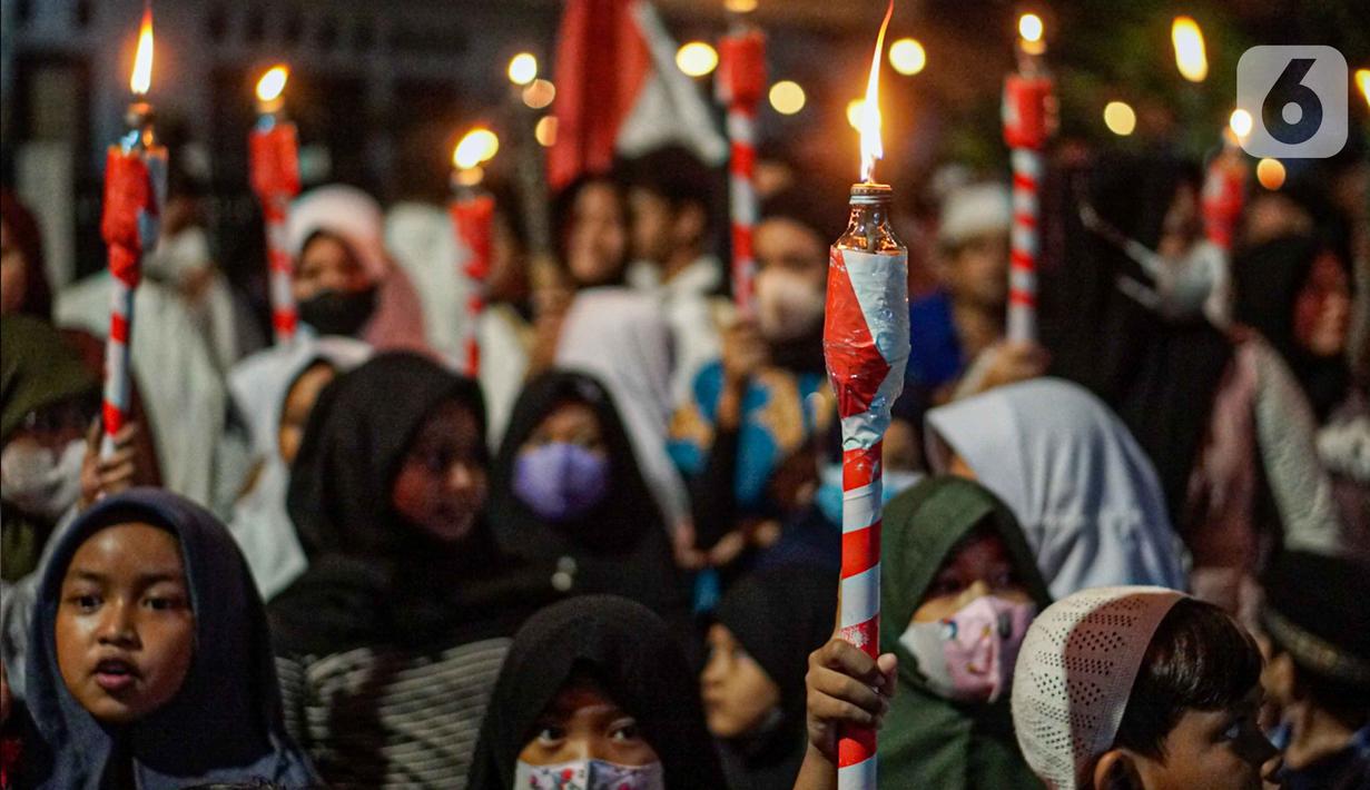 Warga mengikuti pawai obor menyambut Ramadan di kawasan Matraman Dalam, Jakarta, Minggu (27/3/2022). Pawai obor tersebut juga digelar untuk meningkatkan silaturahmi dan ukhuwah sesama umat Muslim serta menyemarakkan syiar Islam di Ibu Kota. (Liputan6.com/Faizal Fanani)