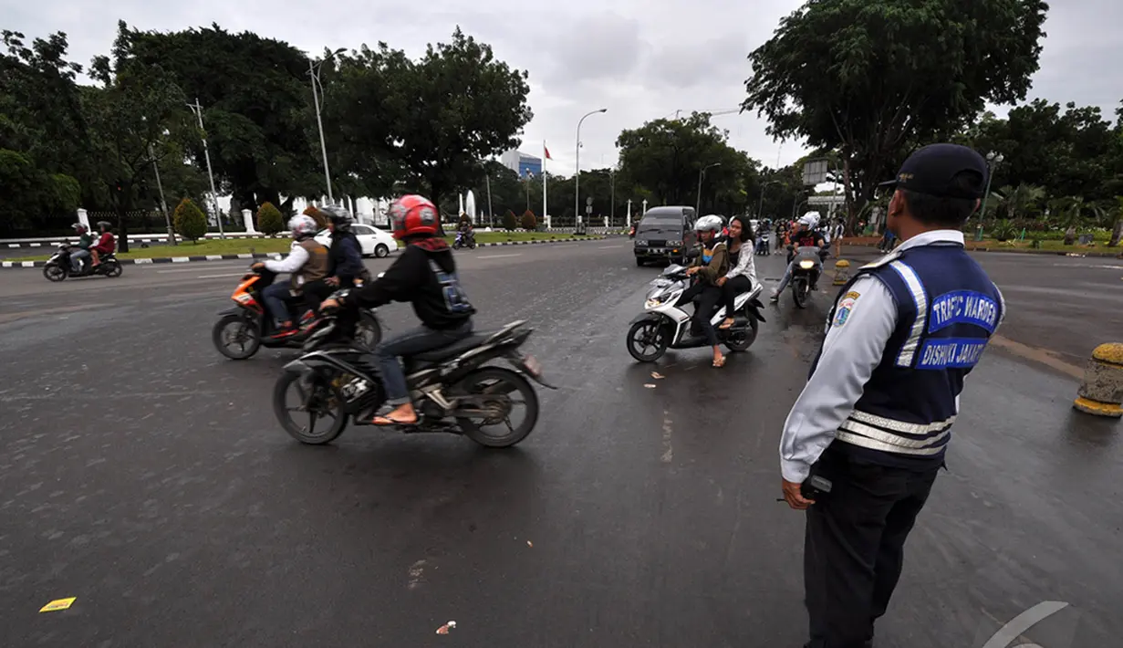 Sejumlah kendaraaan roda dua saat melintasi untuk memasuki kawasan monas, Jakarta, Kamis (1/1/2015). ( Liputan6.com/Miftahul Hayat)