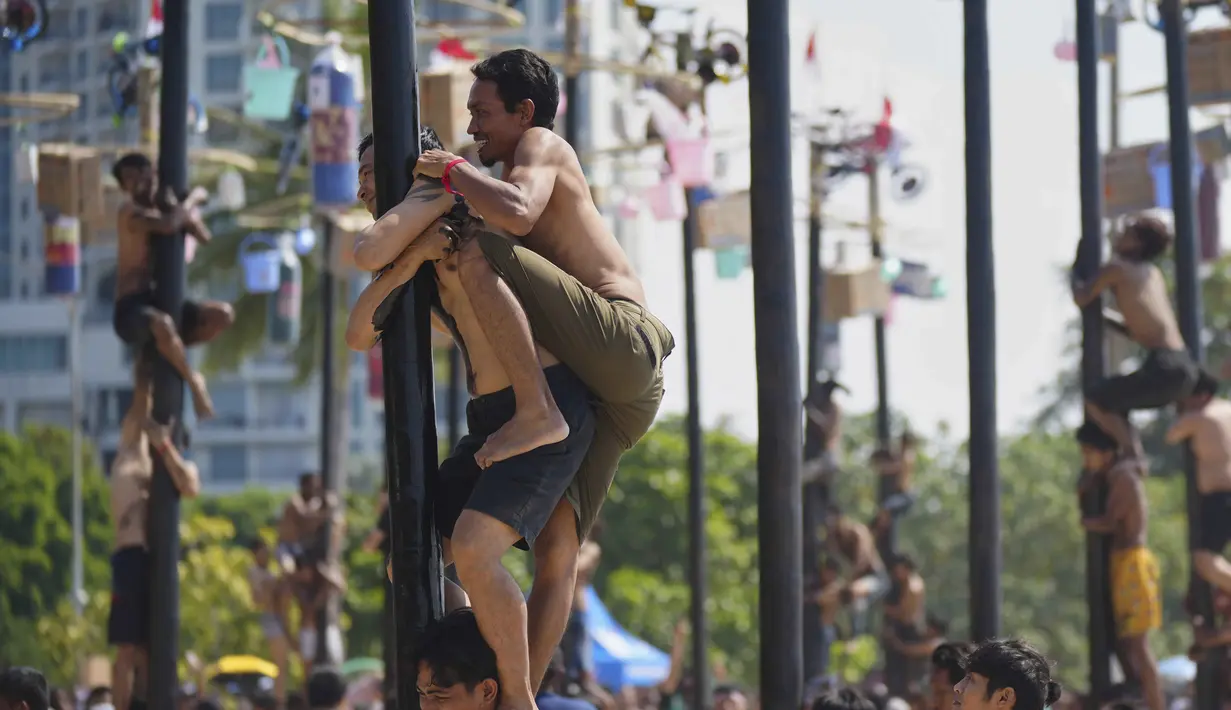 Dalam rangka menyemarakkan HUT ke-80 RI, Pantai Ancol menggelar perlombaan panjat pinang secara kolosal. (AP Photo/Tatan Syuflana)