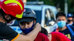 Seorang anggota lembaga swadaya masyarakat membagikan helm dan selempang reflektif secara gratis kepada pengendara sepeda di Manila, Filipina (9/7/2020). (Xinhua/Rouelle Umali)