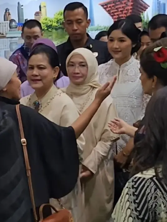 Erina tampil dengan atasan putih brokat dengan kerah sedikit tinggi saat mendampingi Iriana yang berbaju coklat. @_nolabel_