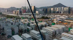 Foto udara menunjukkan lokasi pembangunan fasilitas isolasi sementara untuk menampung pasien Covid-19 yang sedang dibangun di Terminal Kapal Pesiar Kai Tak, Hong Kong (6/4/2022). Bangunan tersebut akan berisi 1.000 tempat tidur dan diharapkan bisa mengurangi beban di rumah sakit umum. (AFP/Yan Zhao)