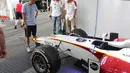 Ayahanda Rio Haryanto, Sinyo Haryanto (kiri), melihat kondisi mobil putra bungsunya usai lomba. (Bola.com/Reza Khomaini)