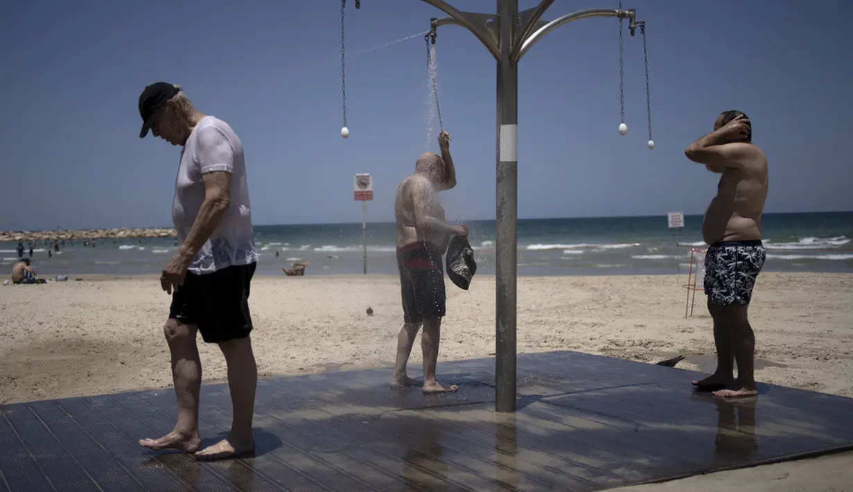 <p>Para pria mandi di pantai umum saat mereka mendinginkan diri dari gelombang panas di Tel Aviv, Israel, Kamis (13/7/2023). Menurut laporan berita lokal pada hari Rabu, Badan Meteorologi Israel telah mengeluarkan peringatan panas yang parah tentang risiko dehidrasi dan serangan panas. (AP Photo/Maya Alleruzzo)</p>