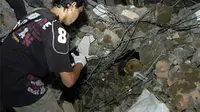 Seorang anggota tim Forensik Polda Sumbar mengevakuasi tengkorak mayat korban gempa yang ditemukan saat pembersihan puing-puing reruntuhan bangunan di kawasan pasar dekat Adabiah Padang, Sumbar. (ANTA