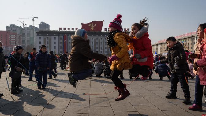 Sejumlah anak bermain lompat tali saat merayakan hari libur Tahun Baru Imlek di alun-alun Kim Il Sung di Pyongyang, Korea Utara (16/2). Dalam perayaan Imlek di Korea Utara ini tidak terlihat ornamen dan aksesoris khas Tionghoa. (AFP Photo/Kim Won-Jin)