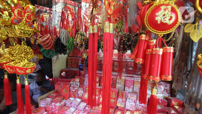 Pedagang menunggu pembeli pernak-pernik khas Imlek di kawasan Tangerang, Sabtu (6/2/2021). Pandemi virus corona COVID-19 membuat para pedagang pernak-pernik Tahun Baru Imlek di kawasan tersebut mengeluh karena menurunnya penjualan dibandingkan tahun-tahun sebelumnya. (Liputan6.com/Angga Yuniar)