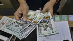 Seorang menghitung uang kertas Dolar AS di salah satu kantor penukaran uang, Jakarta, Selasa 12 Mei 2026. Nilai tukar rupiah terhadap dolar Amerika Serikat (USD) terpuruk pada perdagangan Selasa (12/5/2026). (BAY ISMOYO/AFP)