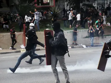 Seorang demonstran menendang gas air mata yang ditembakkan Polisi Anti Huru hara, Brasil, Jumat (8/1/2016). Pengunjuk rasa protes terhadap kenaikan tarif untuk bus kota di Sao Paulo. (Reuters/Nacho Doce)