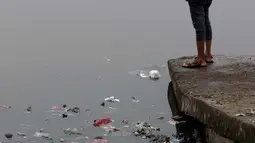 Warga memancing di bibir Waduk Cincin, Jakarta, Sabtu (19/6/2021). Ceceran sampah plastik ini mengganggu kemyamanan warga yang ingin menikmati suasana Waduk Cincin . (Liputan6.com/Helmi Fithriansyah)