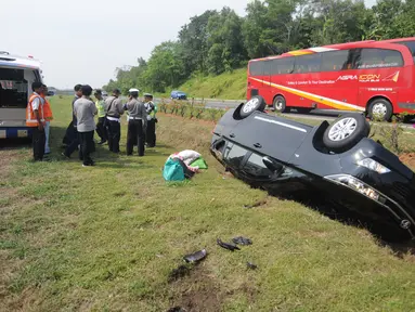 Mobil Innova terbalik di jalur rumput di KM 208 Tol Palikanci (Palimanan-Kanci), Jawa Barat, Rabu (21/6). Pengemudi mobil bernopol B 2247 TKL itu diduga mengantuk dan membanting setir hingga mengakibatkan mobil terbalik. (Liputan6.com/Gempur M Surya)