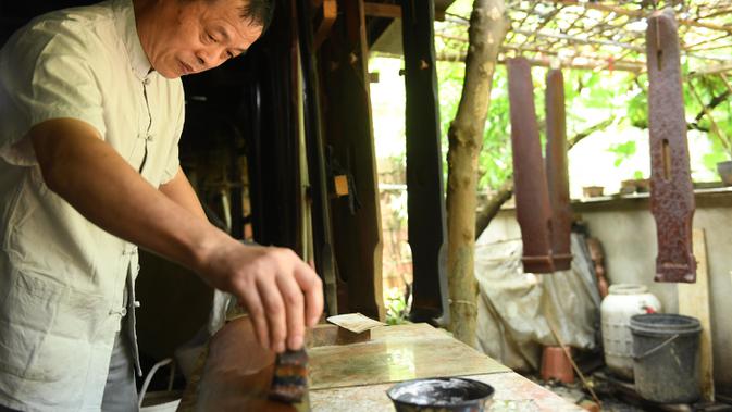 Ma Yuesi mengecat Guqin, alat musik tradisional China, di kediamannya di Desa Yalan, Distrik Yuhang, Hangzhou, Provinsi Zhejiang, China timur, pada 30 Juni 2020. Ma Yuesi (58) memutuskan menjadi pembuat Guqin sejak berusia 24 tahun. (Xinhua/Weng Xinyang)