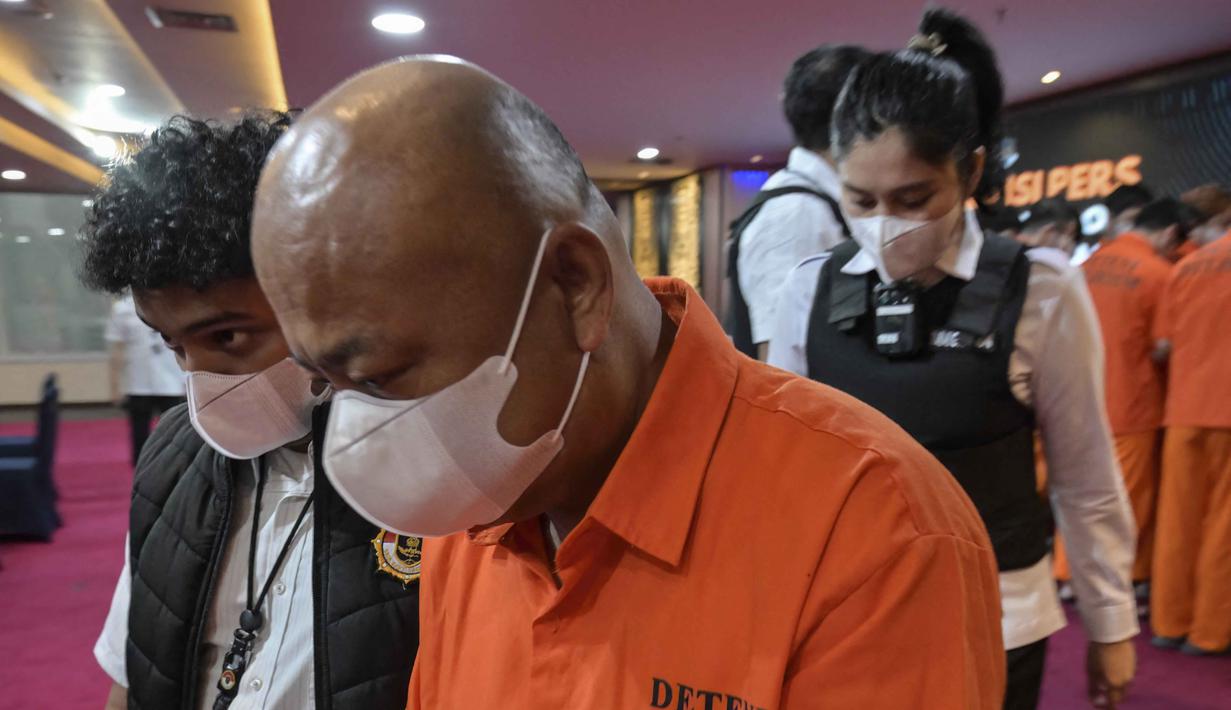 Salah seorang yang ditangkap berinisial WZ merupakan tersangka yang dicari pihak berwenang China atas kasus penipuan senilai 120 juta USD. Tampak dalam foto, petugas Imigrasi Indonesia mengawal tahanan di Kantor Imigrasi Jakarta pada Selasa 18 November 2025. (BAY ISMOYO/AFP)