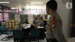 Proses penyortiran dan pelipatan surat suara Pemilu 2024 diawasi langsung petugas Bawaslu Kepulauan Seribu dan Polres Kepulauan Seribu. (merdeka.com/Imam Buhori)
