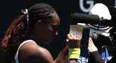 Petenis Amerika Serikat, Coco Gauff menuliskan pesan untuk korban kebakaran dan pemadam kebakaran di Los Angeles, Amerika setelah menang atas kompatriotnya, Sofia Kenin pada hari kedua Australia Open 2025 di Melbourne, Australia, Senin (13/01/2025). (AFP/David Gray)