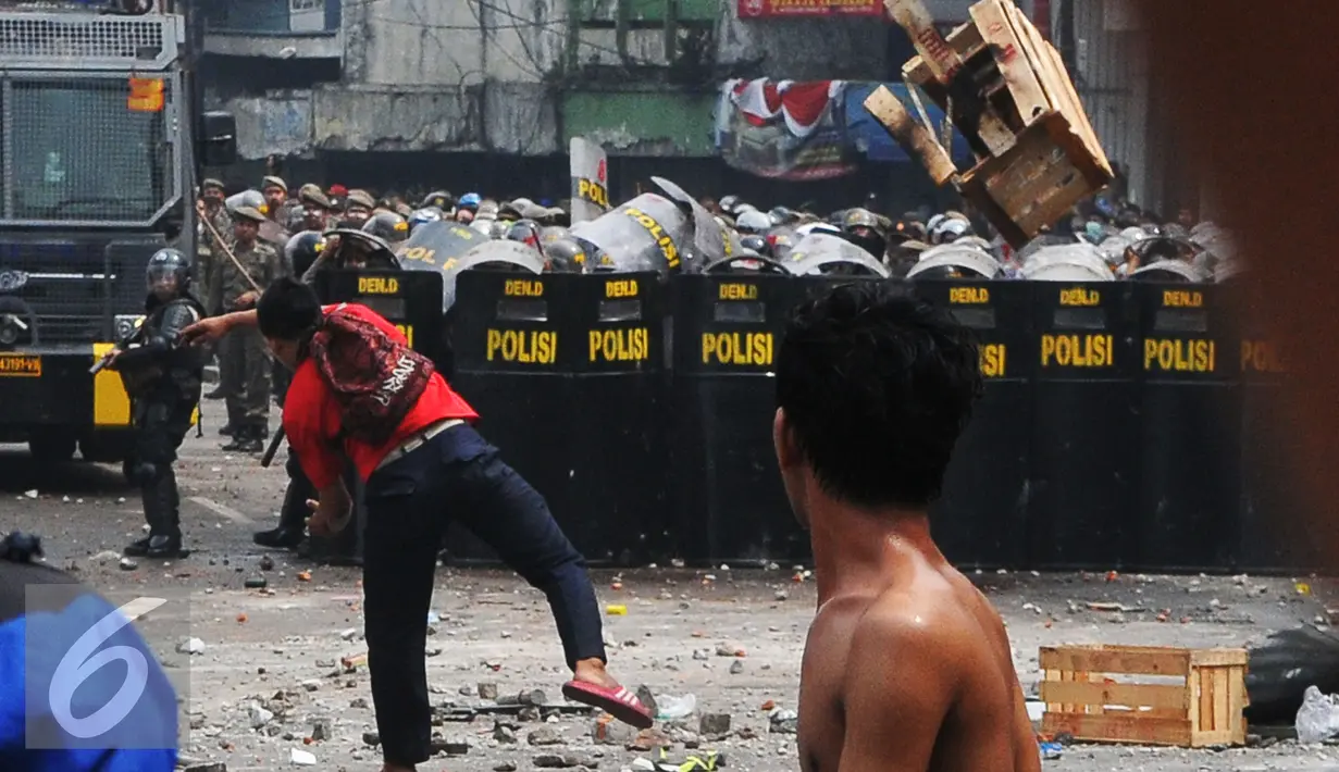 Warga Kampung Pulo menyerang Petugas saat penggusuran Kampung Pulo, Jakarta, Kamis (20/8/2015). Penggusuran pemukiman Kampung Pulo dilakukan oleh 2.200 personel gabungan untuk normalisasi Sungai Ciliwung. (Liputan6.com/Herman Zakharia)
