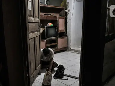 Warga memperbaiki pintu rumahnya yang rusak akibat sering terendam banjir di kawasan RW 07 Rawajati, Jakarta, Selasa (22/9/2020). RW 07 Rawajati merupakan salah satu permukiman di pinggir Kali Ciliwung yang kerap terendam banjir kiriman dari Bogor walaupun tidak hujan. (merdeka.com/Iqbal S. Nugroho)