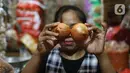 Pedagang memperlihatkan bawang bombay dagangannya di dPasar Induk Kramat Jati, Jakarta, Kamis (12/3/2020). Para pedagang di pasar tradisional, mengeluhkan harga bawang bombay yang melonjak drastis hingga 10 kali lipat dari harga normal. (Liputan6.com/Herman Zakharia)