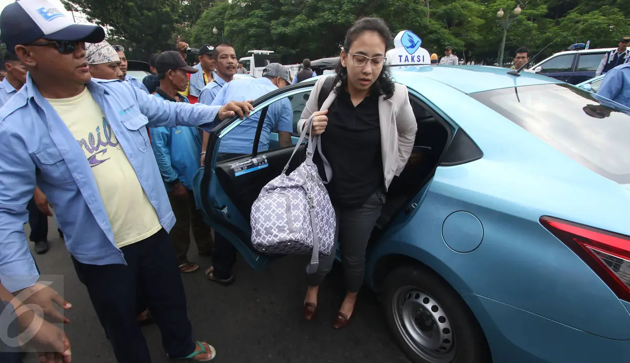 Seorang penumpang dipaksa turun oleh para sopir taksi yang melakukan aksi sweeping di Jalan Medan Merdeka Selatan, Jakarta, Senin (14/3). Ribuan sopir taksi dan bus kota akan menggelar unjuk rasa di Istana hari ini. (Liputan6.com/Immanuel Antonius)