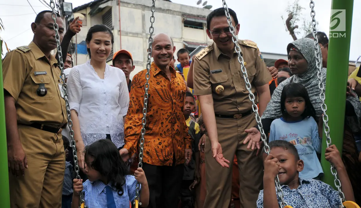 Basuki Tjahaja Purnama didampingi Veronica Tan  meninjau anak-anak yang bermain ayunan di RPTRA Cililitan, Jakarta, 22 Oktober 2015. Pengacara Ahok mengaku tidak bisa mengungkapkan alasan kliennya menggugat cerai Veronica. (Liputan6.com/Gempur M Surya)