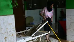 Murid SMA Negeri 8 Jakarta membersihkan lumpur sisa banjir di sekolahnya di Bukit Duri, Tebet, Sabtu (4/1/2020). Data Kemendikbud menyebutkan per 3 Januari 2020 terdapat 201 sekolah terendam banjir dan 89 sekolah mengalami gangguan pada akses menuju sekolah. (Liputan6.com/Herman Zakharia)