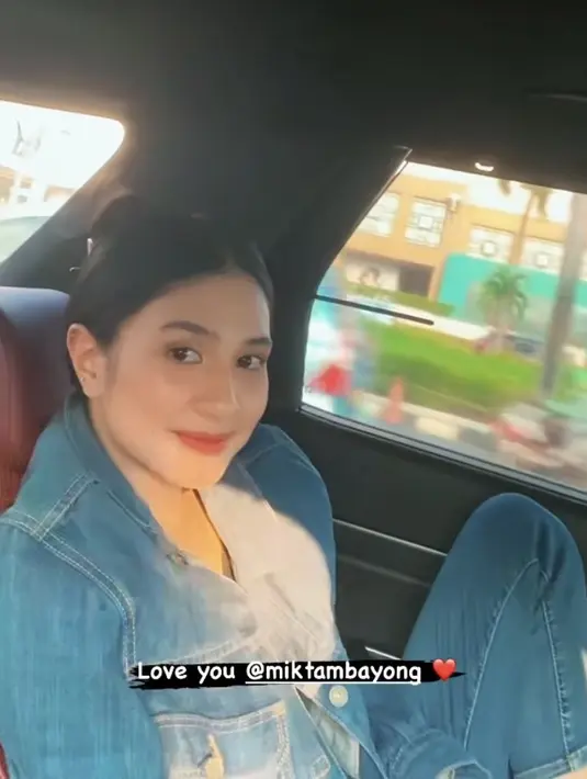 Di dalam sebuah mobil, Deva Mahenra membuat story media sosialnya. Ia merekam tingkah manis istrinya, Mikha Tambayong saat mengenakan bajunya. [@devamahenra]